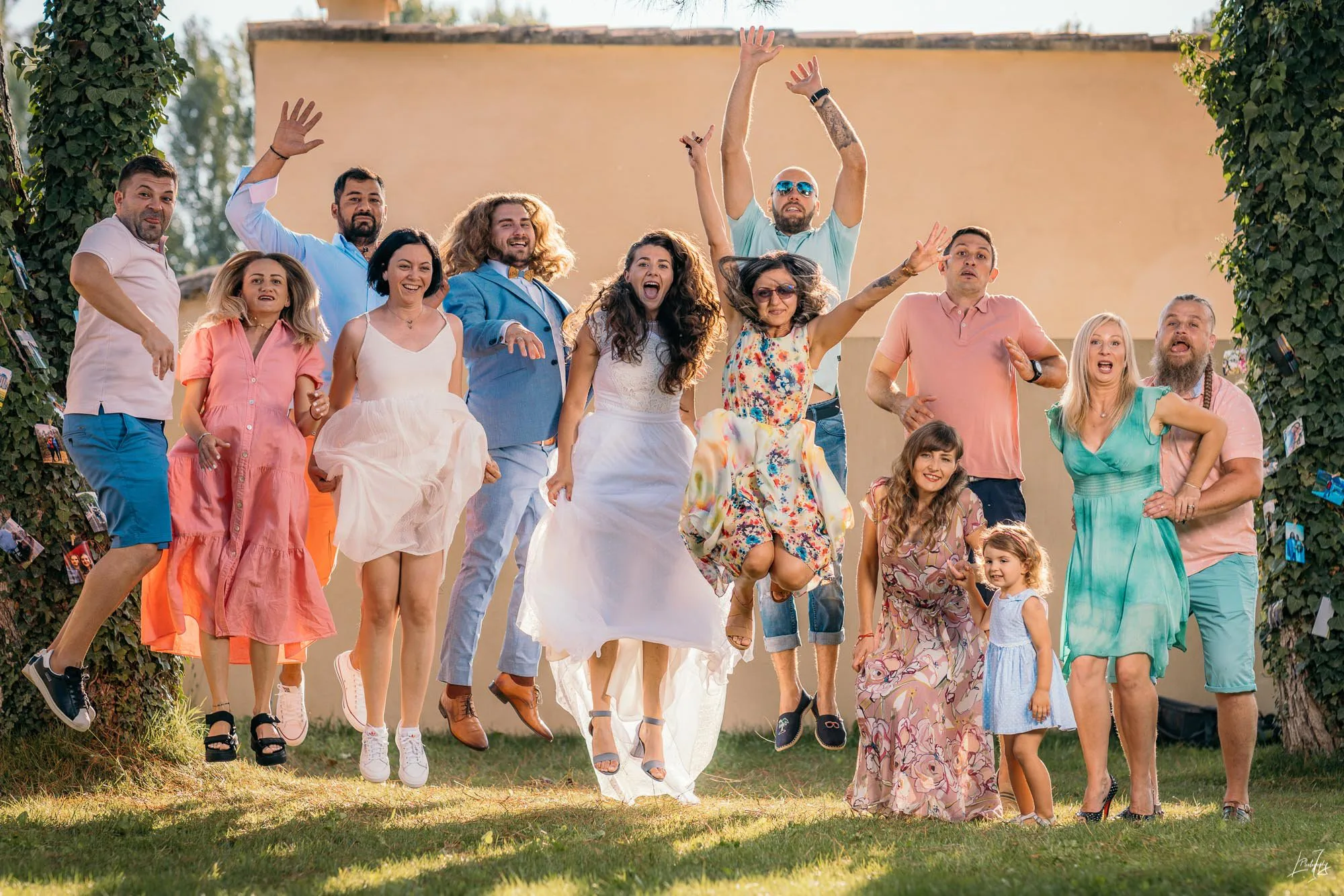 Les mariés entourés de leurs amis qui sautent de joie