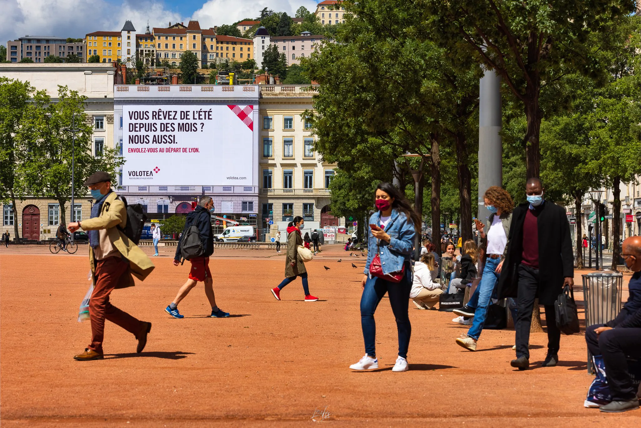 Bâche publicitaire Volotea place Bellecour, passants au premier plan