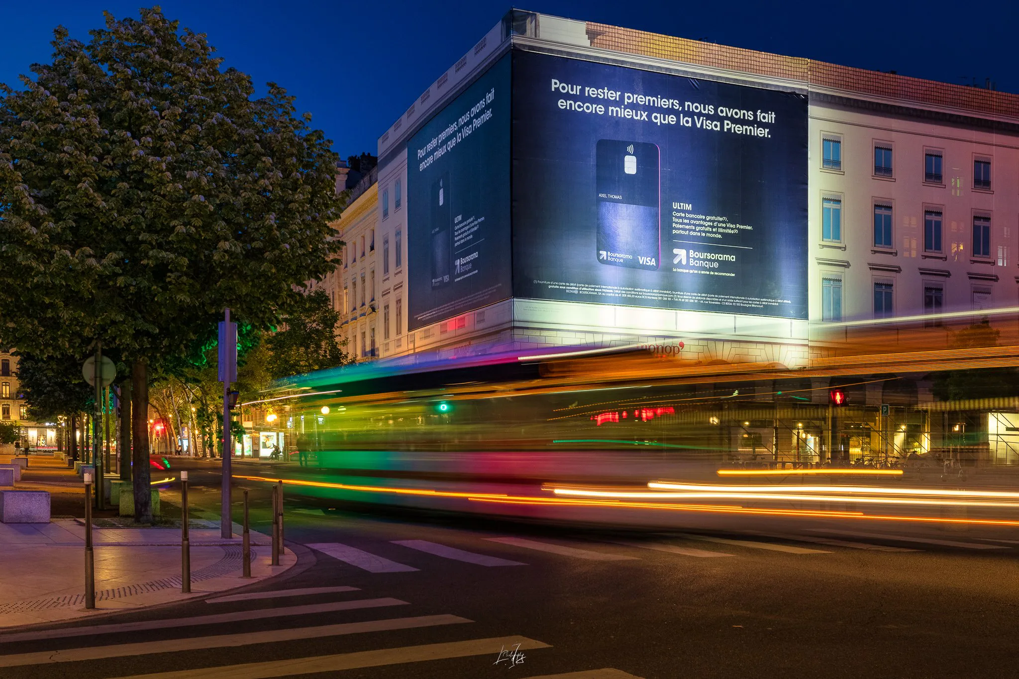 Bâche publicitaire Boursorama place Bellecour de nuit, filé lumineux du tramway