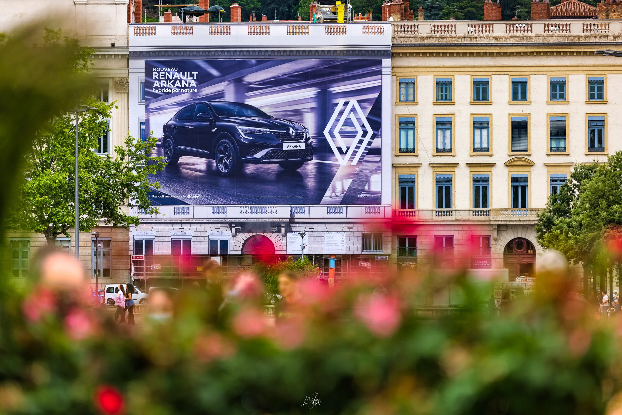 Bâche publicitaire Renault Arkana place Bellecour, fleurs au premier plan