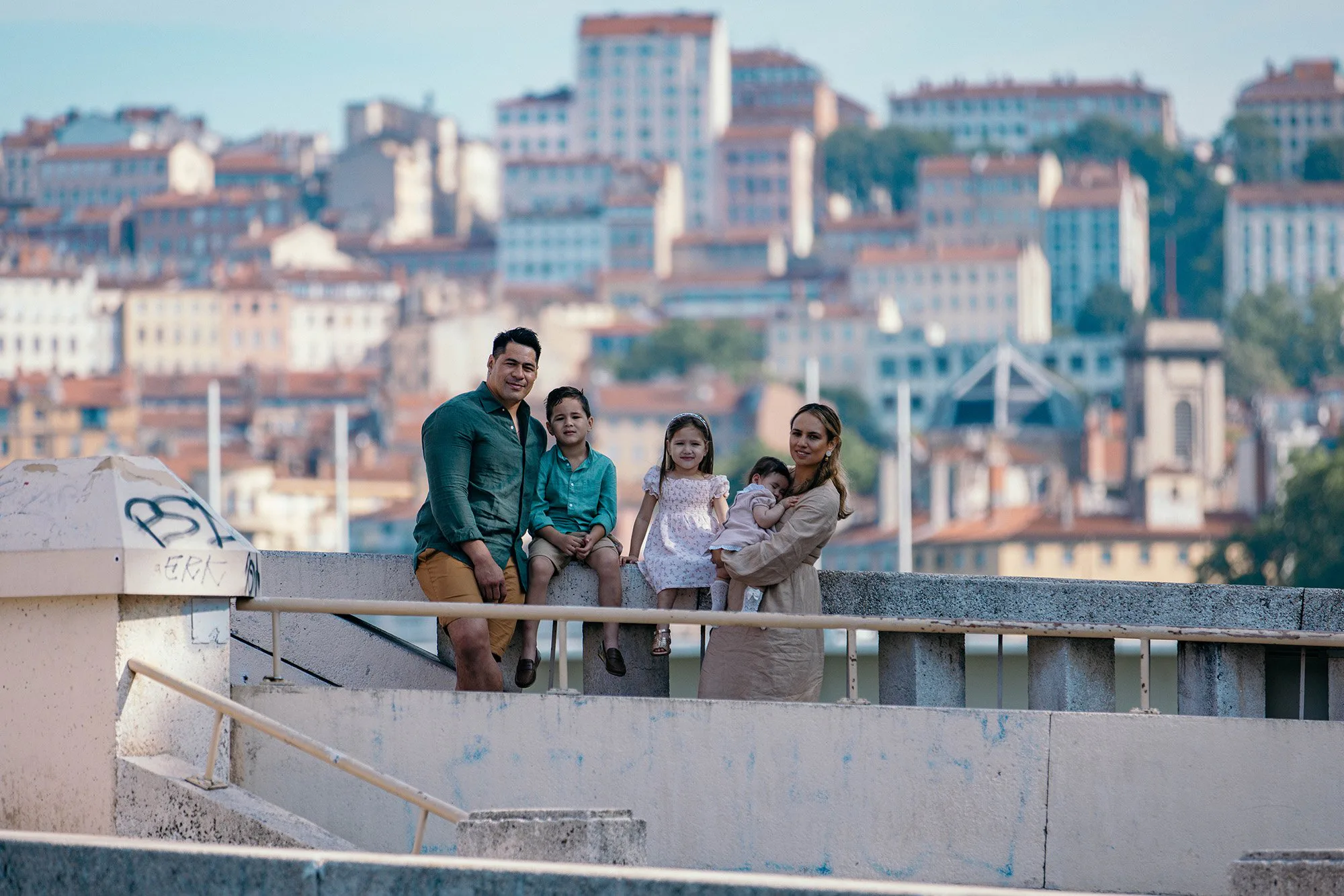Portrait de famille sur une terrasse avec vue sur les toits de Lyon