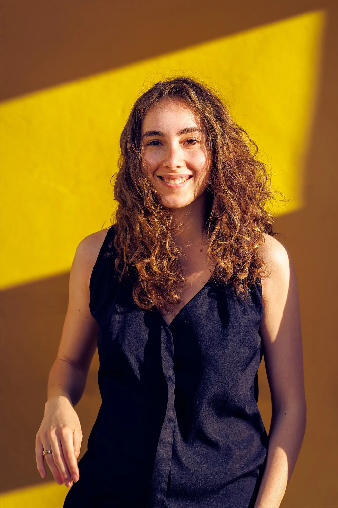 Portrait créatif d’une jeune femme souriante sur fond coloré, réalisé par un photographe portrait lifestyle à Lyon et dans le Rhône.