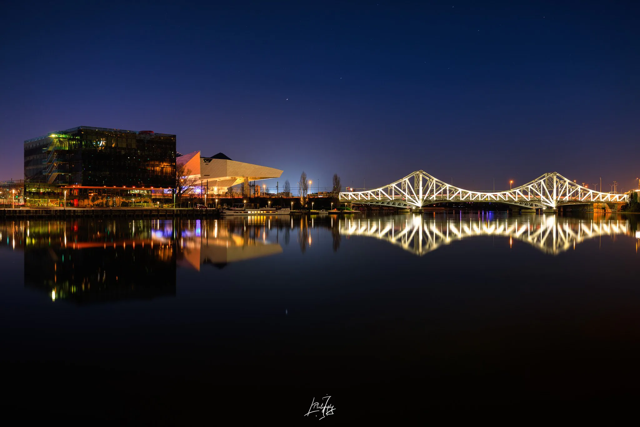 Lyon la nuit : reflets d’un pont illuminé et du quartier de Confluence