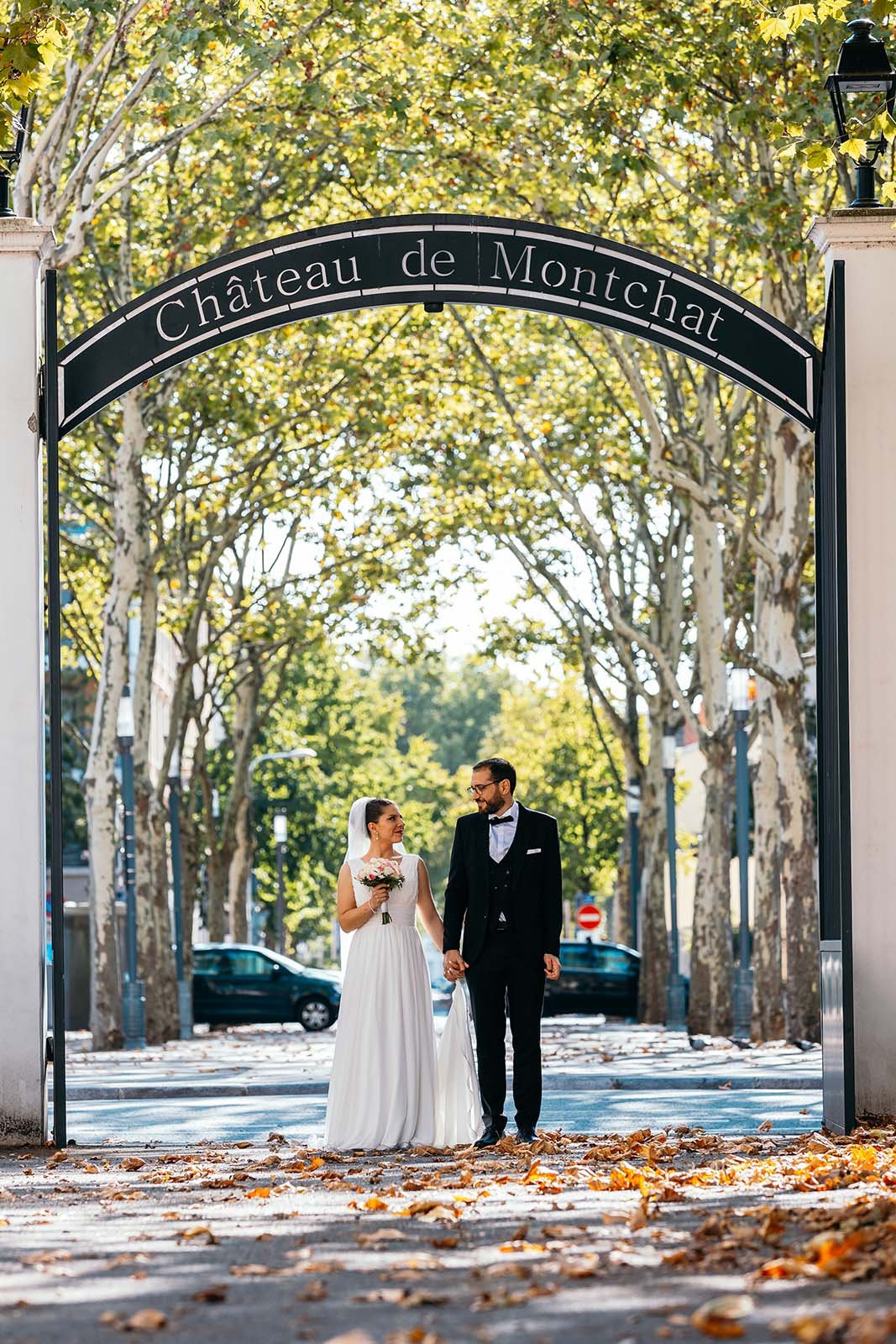 Les mariés sous la grille d’entrée du Château de Montchat, à Lyon
