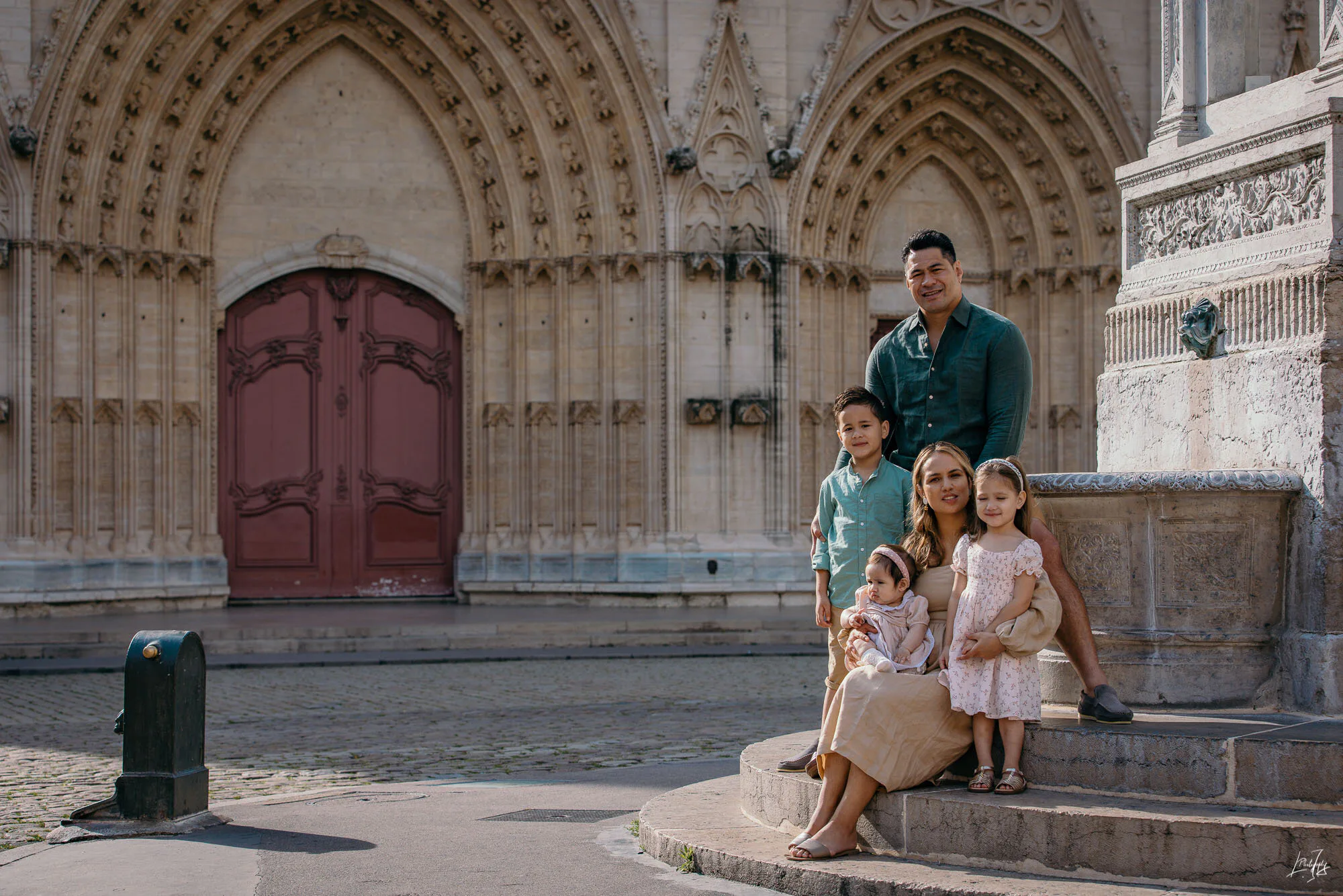Portrait de famille devant bâtiment historique, photographie professionnelle réalisée par un photographe famille à Lyon.