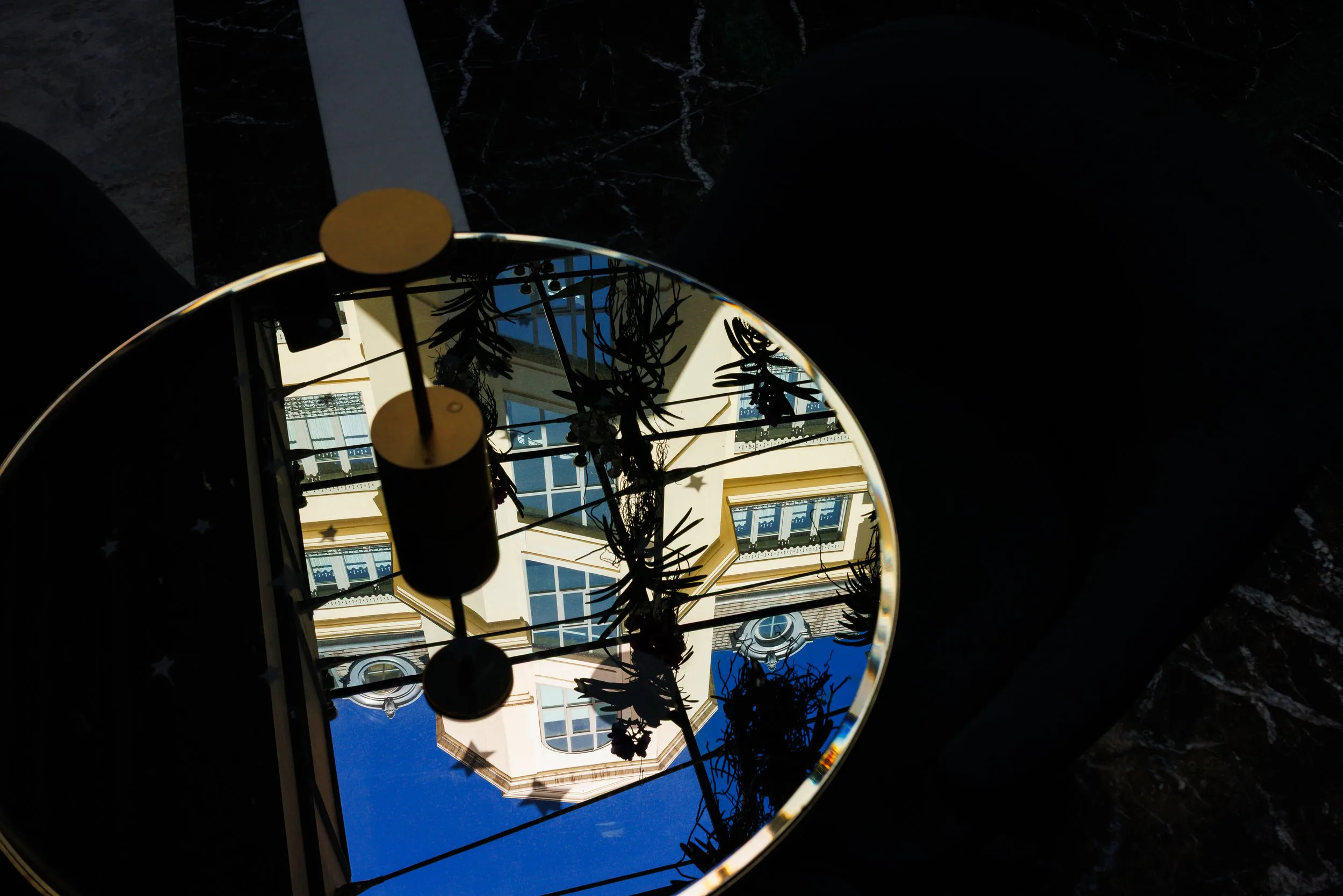 Reflet d'un bâtiment résidentiel dans un miroir rond placé sur une table en marbre