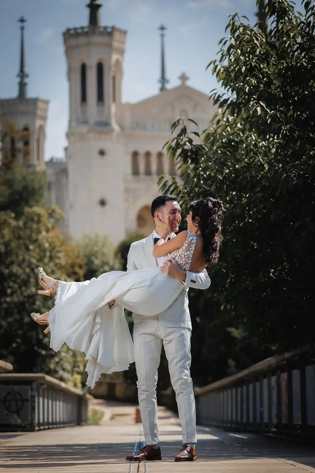 Le marié porte la mariée devant la basilique de Fourvière — mariage de Dima et Enzo à Lyon