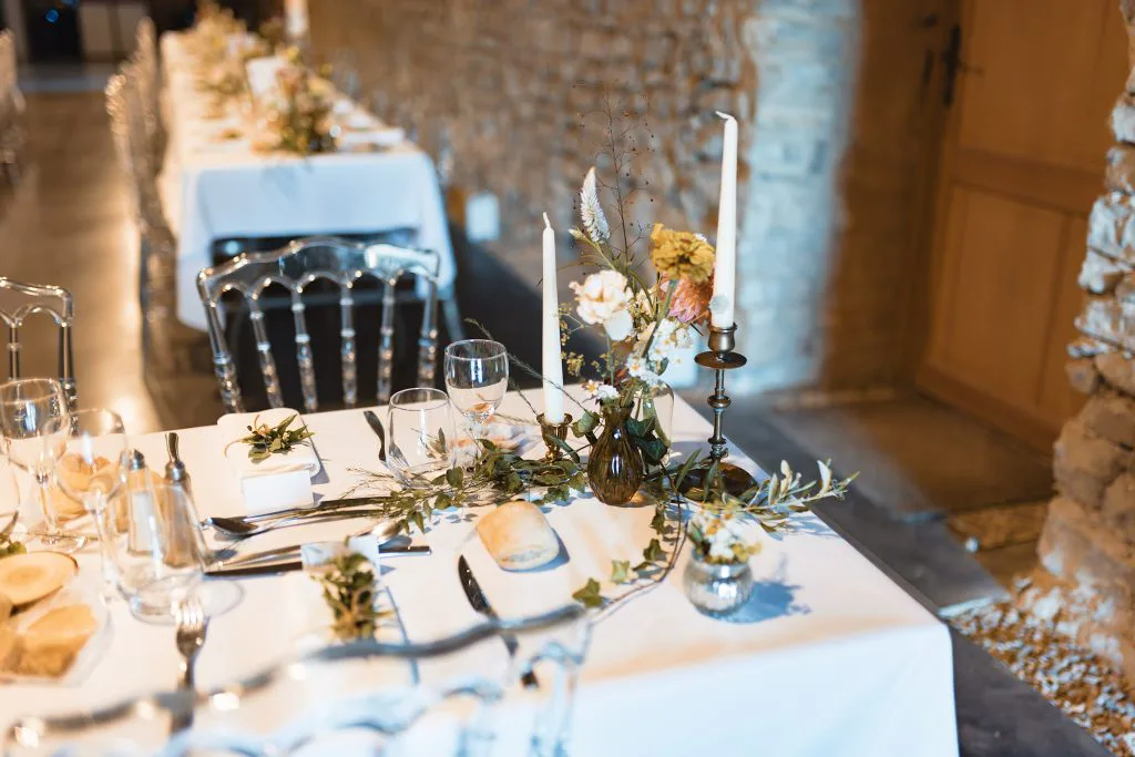 Tables du dîner sous la voûte en pierre, bougies et compositions florales