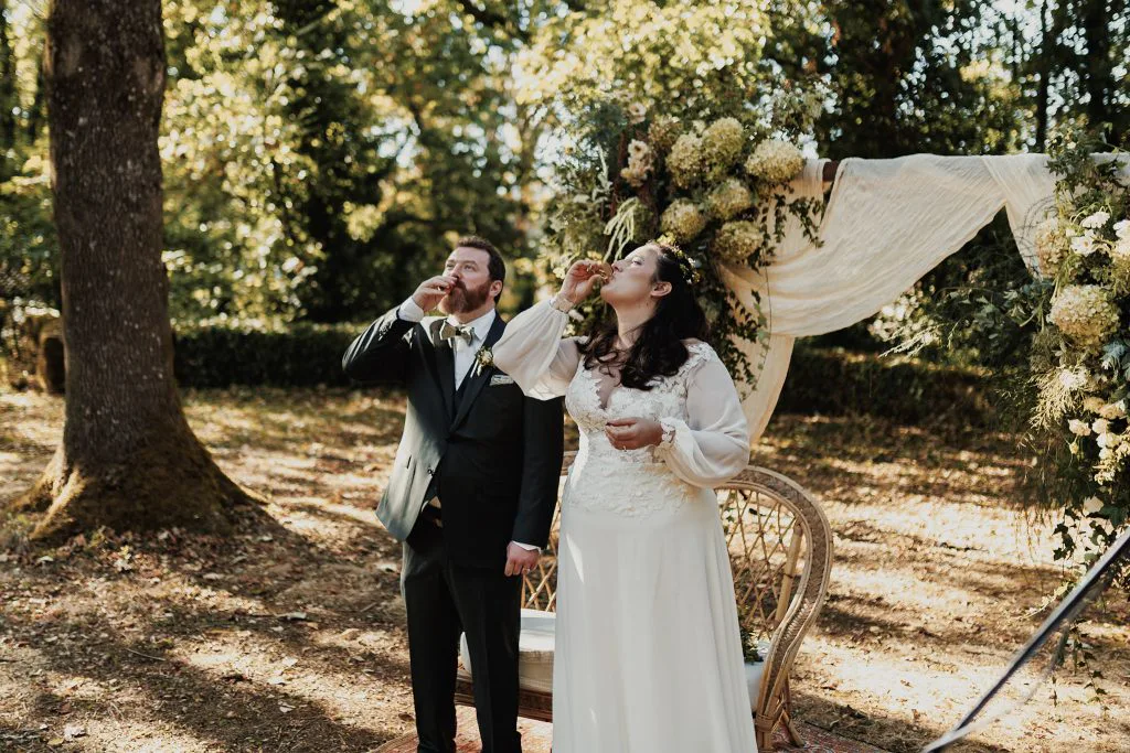 Camille et Jason boivent leur shot d’un trait sous l’arche fleurie, en même temps que tous leurs invités