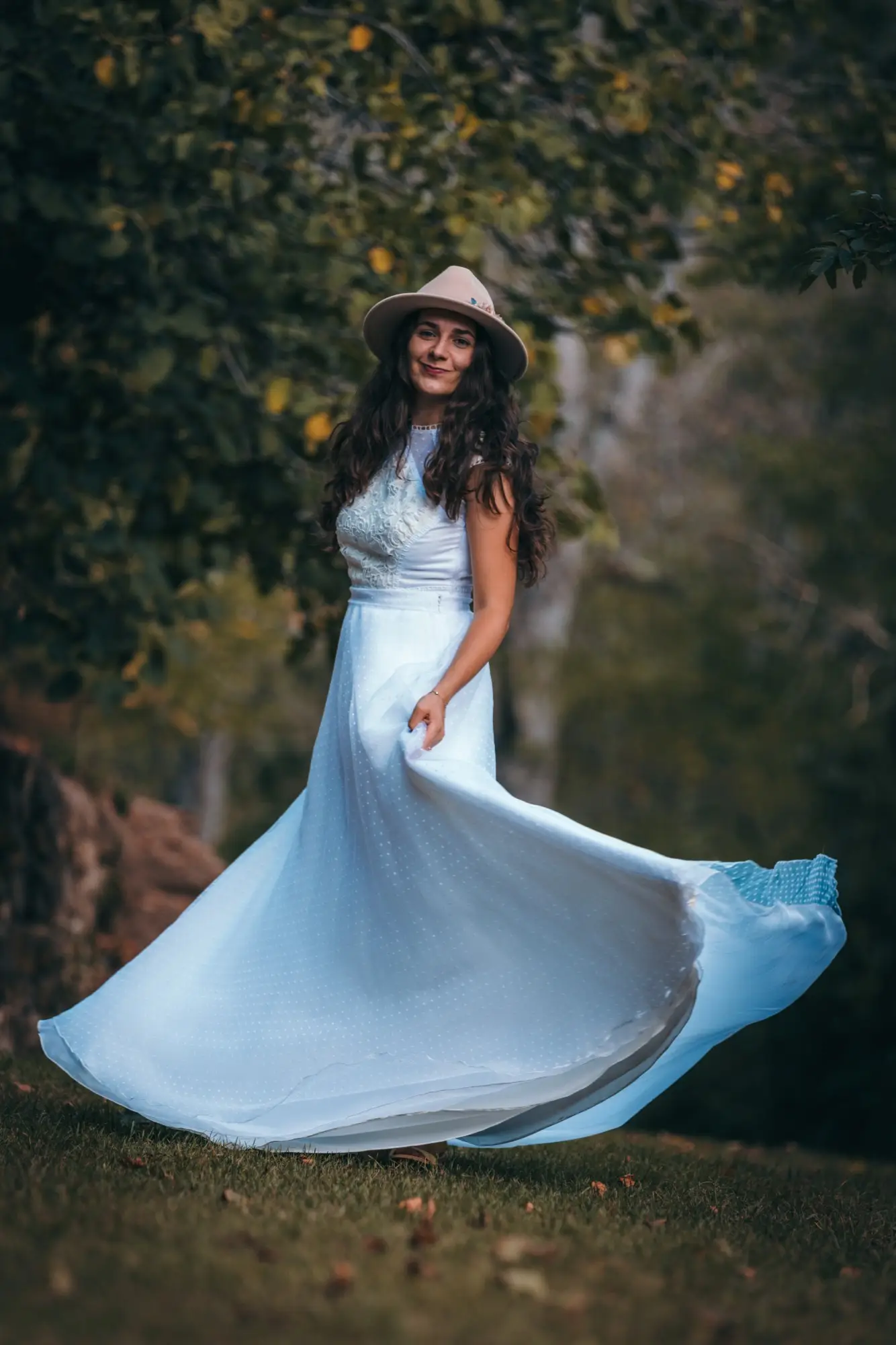 Portrait lifestyle en robe blanche et chapeau, robe en mouvement dans un parc — photographe portrait à Lyon